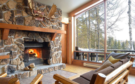 Foyer avec bois chauffage inclus chalet vacances Laurentides avec sauna et spa privé vue sur l'eau